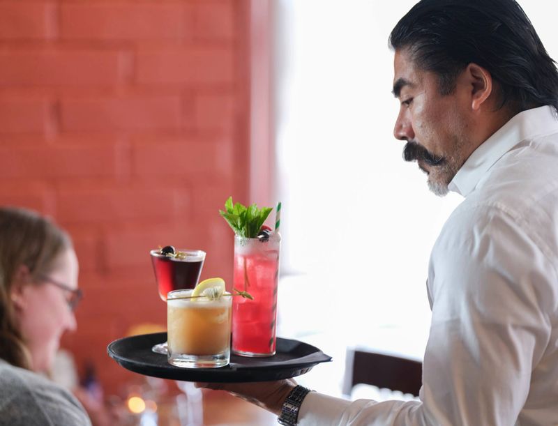 A waitress serving drinks to guests at Alfredo's Pastaria and Mozzarella Bar.