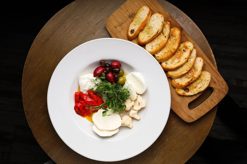 A plate with fresh bread and a vegetable dish at Alfredo's Pastaria and Mozzarella Bar.