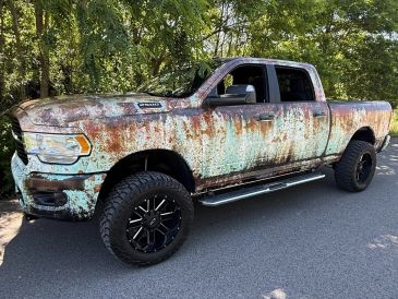 Rusty pickup truck parked on road.