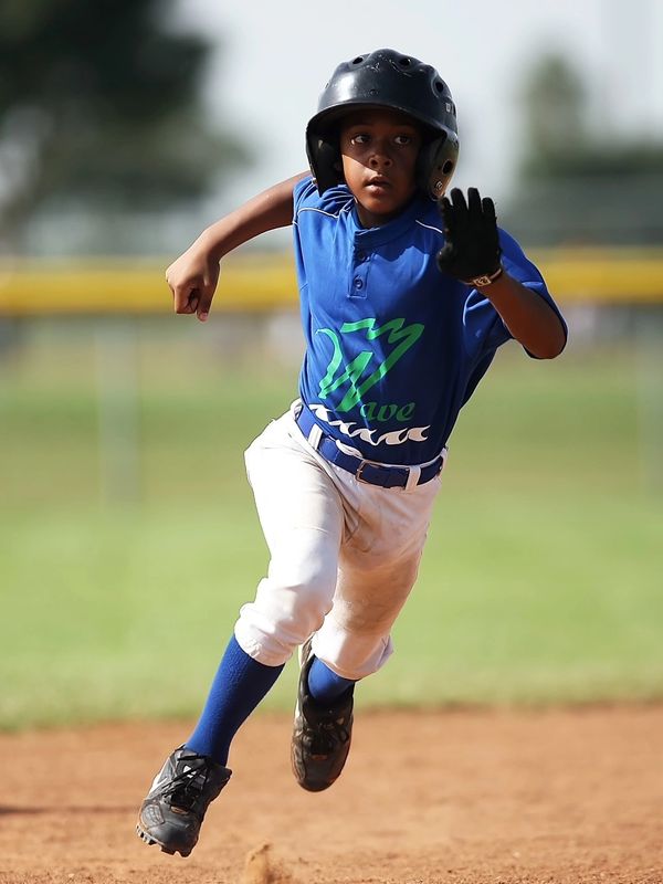 Boy running to base playing baseball