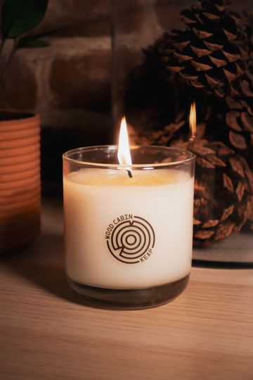Lit white candle in a glass jar.