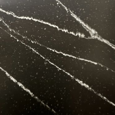 Close-up of black marble with white veins and speckles.