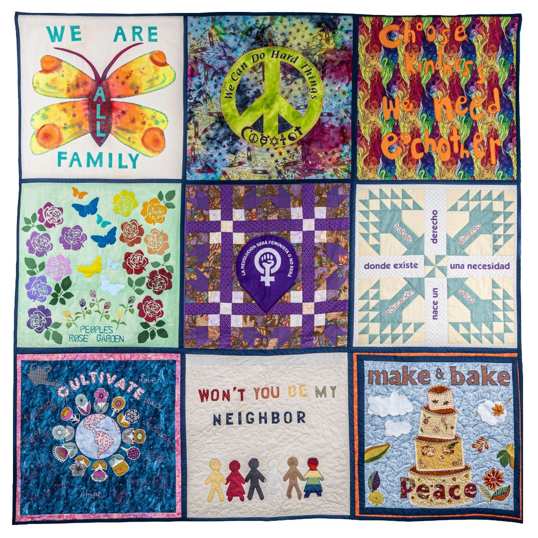 A colorful quilt with messages of peace, kindness, and unity.