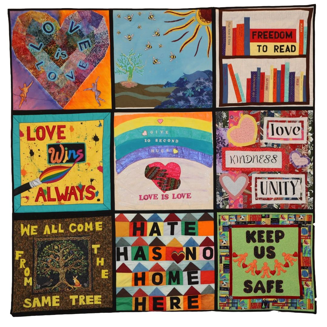 Colorful quilt panels promoting love, unity, and kindness.