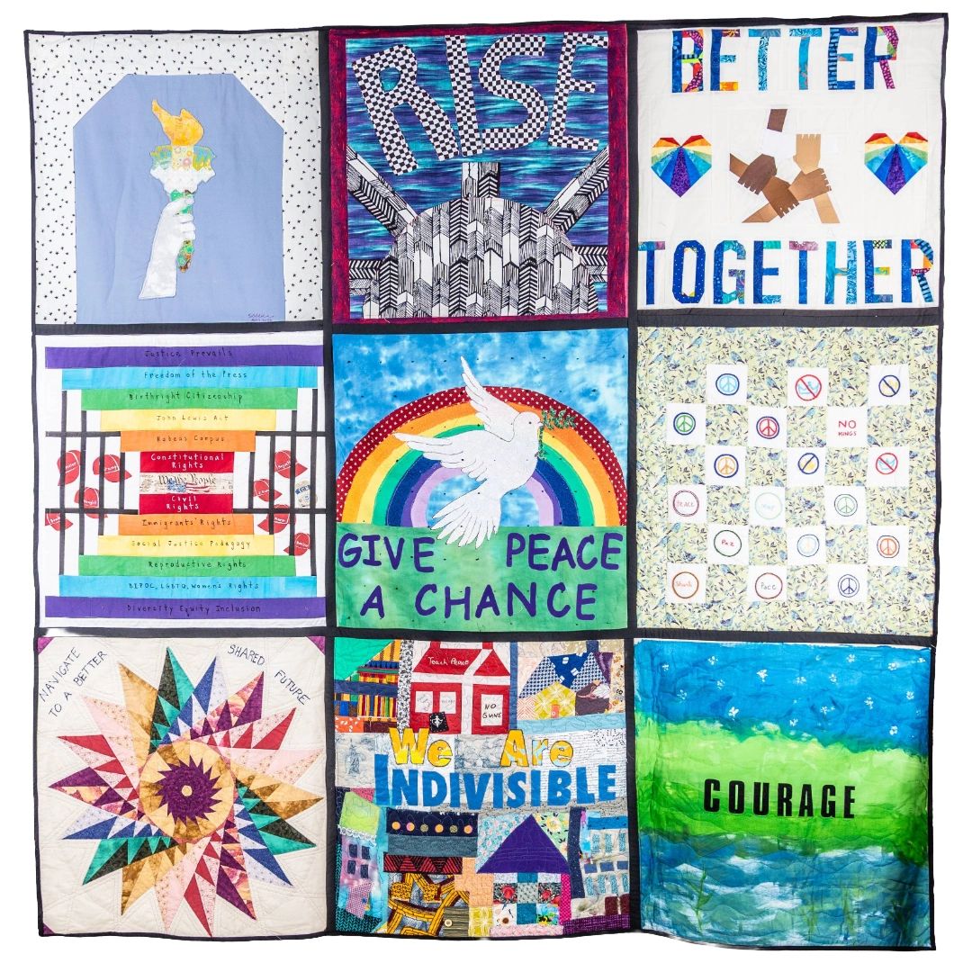 Quilt with messages of peace, unity, and courage in colorful patchwork.