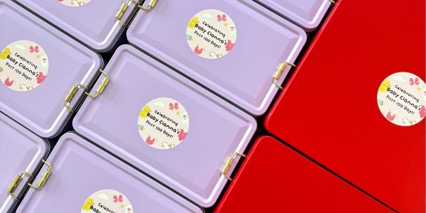 Purple and red boxes with 'Celebrating Baby Gianna's First 100 Days' stickers.