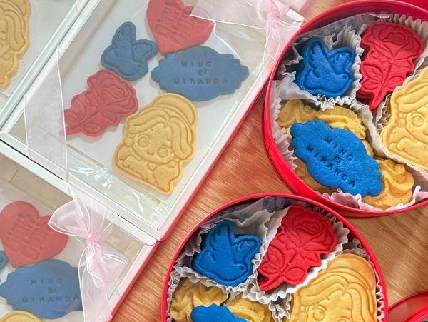 Colorful decorated cookies in shapes including a girl, butterfly, and rose.