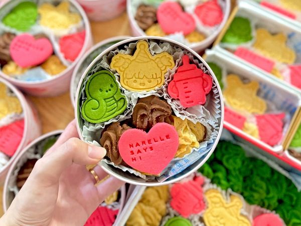 Colorful decorated cookies in a round tin.