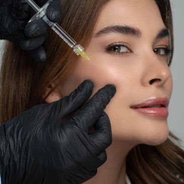 Woman receiving a cosmetic injection in her cheek.