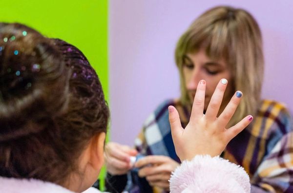 Child showing painted nails to an adult.