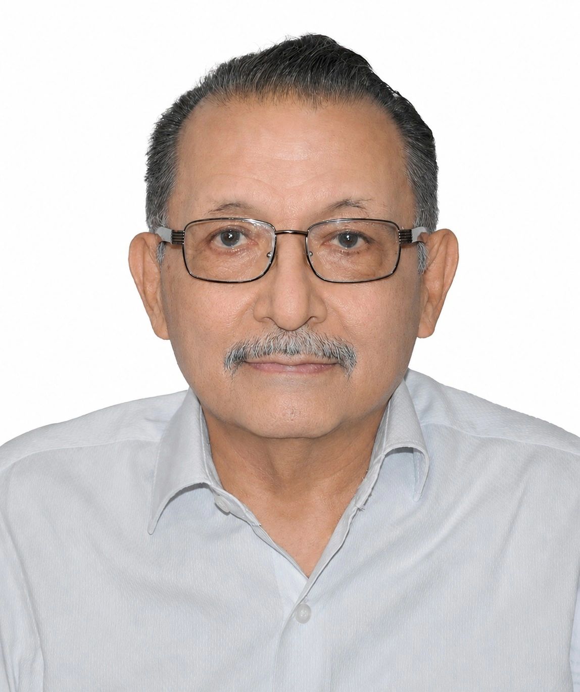 Hombre mayor con gafas y bigote, vestido con camisa clara.