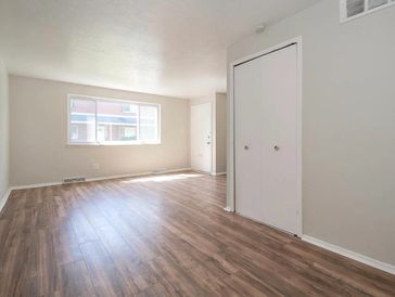 Empty room with wood flooring and white walls.