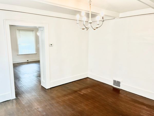 Empty room with wooden floors and white walls.