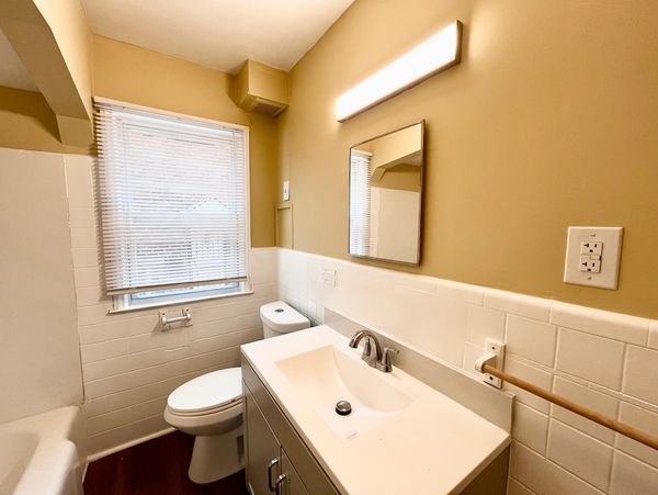 Bright, clean bathroom with white fixtures and beige walls.