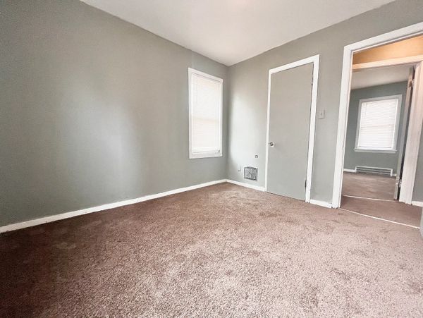 Empty room with beige carpet and light gray walls.