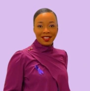 Smiling woman in a purple top with a purple ribbon on a light purple background.