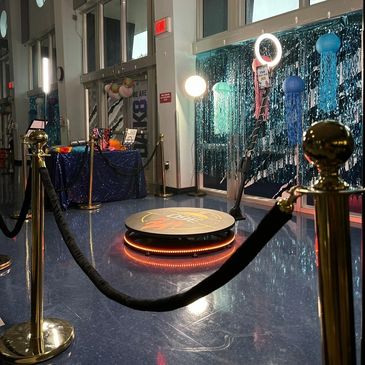 Decorated event space with glowing platform and jellyfish decorations.