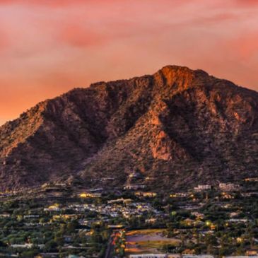Mountain landscape at sunset with a town below.