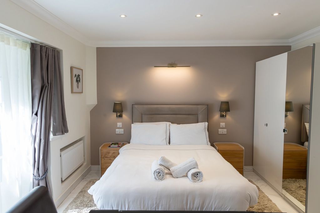 Double bedroom in our lower-ground-floor one-bedroom Marylebone apartment, with a double bed, wardro
