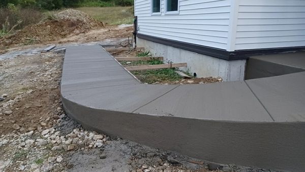 Newly poured concrete patio around a house.