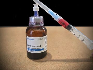 A syringe filled with red liquid next to a bottle labeled LIPO-B Injection.