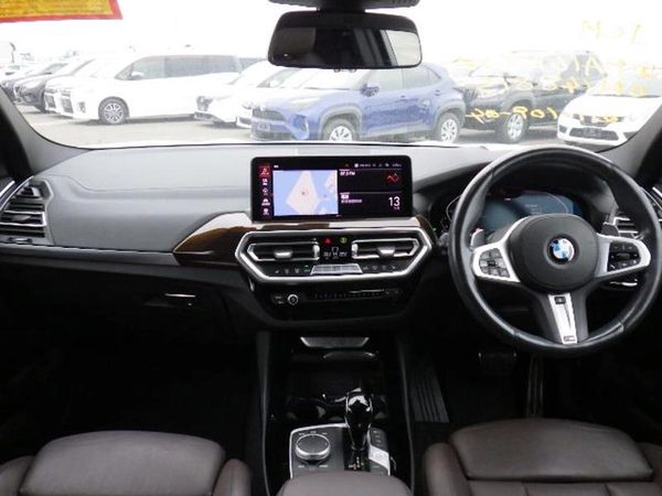 Interior view of a BMW car with a digital dashboard and steering wheel on the right.