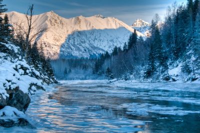 Snowy mountain landscape with icy river.