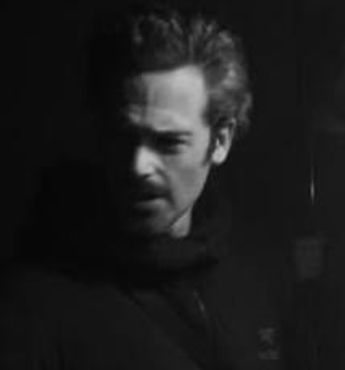 Black and white portrait of a man with intense expression.