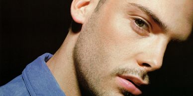 Close-up of a young man's face with a contemplative expression.