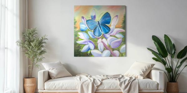 Living room with a karner blue butterfly painting above a white sofa and green plants.