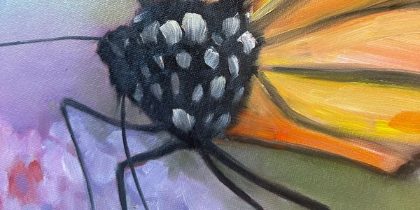 Close-up of a painted monarch butterfly on a purple background.