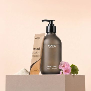 Elegant hand soap bottle with packaging and flower.