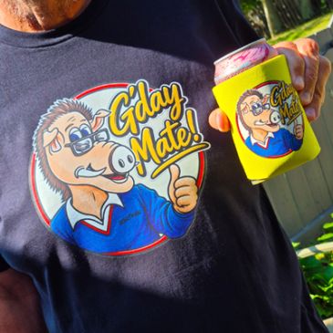 Person wearing a shirt and holding a can cooler with cartoon character and text.
