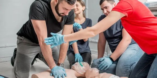 People practicing CPR on a training mannequin.
