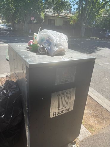Overflowing public rubbish bin