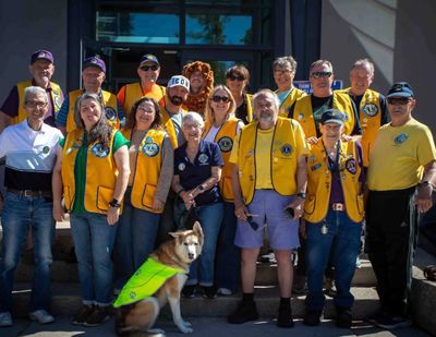 Group of volunteers in yellow vests with a dog wearing a neon vest.
