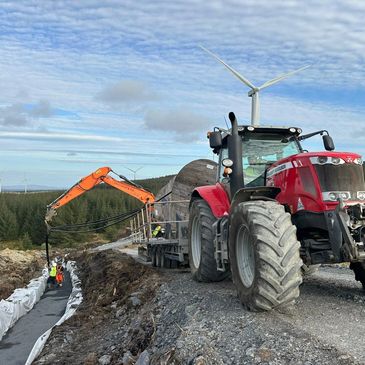 Red tractor and orange excavator working at construction site.