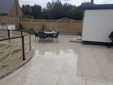 Wet tiled backyard patio with outdoor dining set.