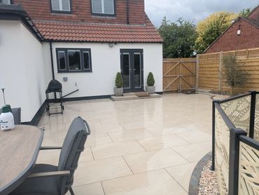 Clean backyard patio with tiled floor and outdoor furniture.