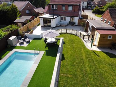 Modern backyard with pool and patio furniture.
