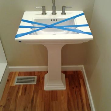 Bathroom sink taped off with blue tape, preventing use.