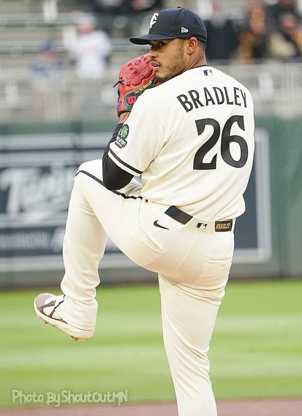 Baseball pitcher Bradley in mid-pitch, wearing a white uniform with number 26.