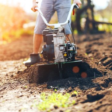 close up photo of gardener cultivate ground soil rototiller , tiller tractor, cutivator