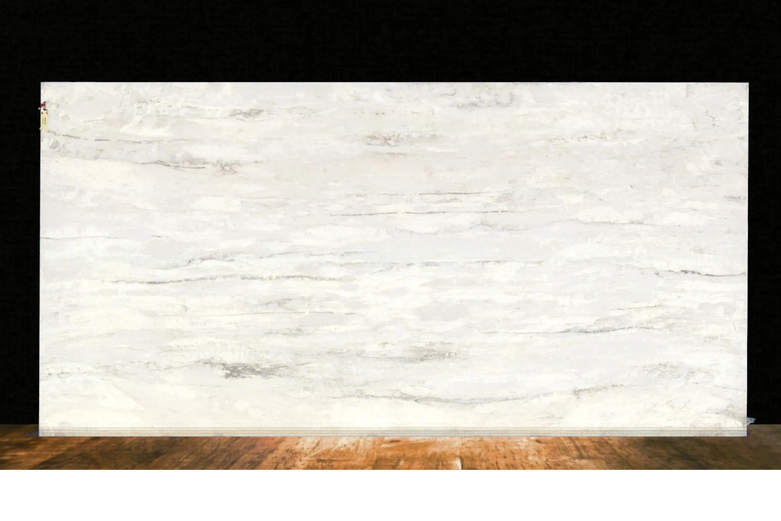 Large white marble slab with subtle gray veining on a wooden floor.