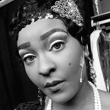 Black & White photo of Iyana Colby, a black woman, in a 1920s flapper headdress