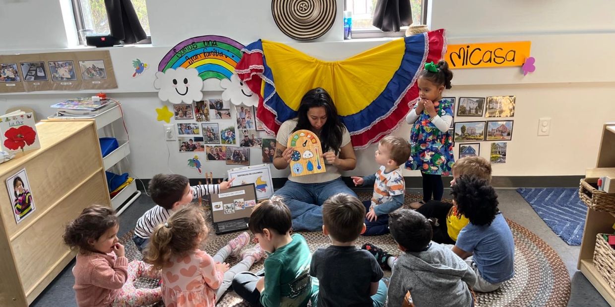 Teacher reading to kids in a colorful classroom.