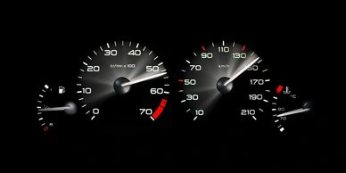Car dashboard showing speed, RPM, fuel, and engine temperature gauges.