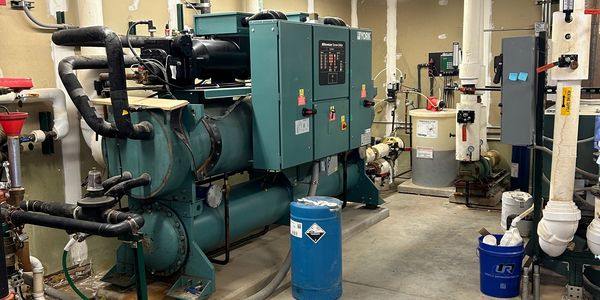 Industrial equipment and piping in a utility room.