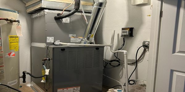 Heating system with pipes and electrical wiring in a utility room.