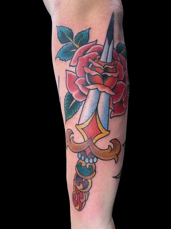 Traditional tattoo of a dagger going through a red rose